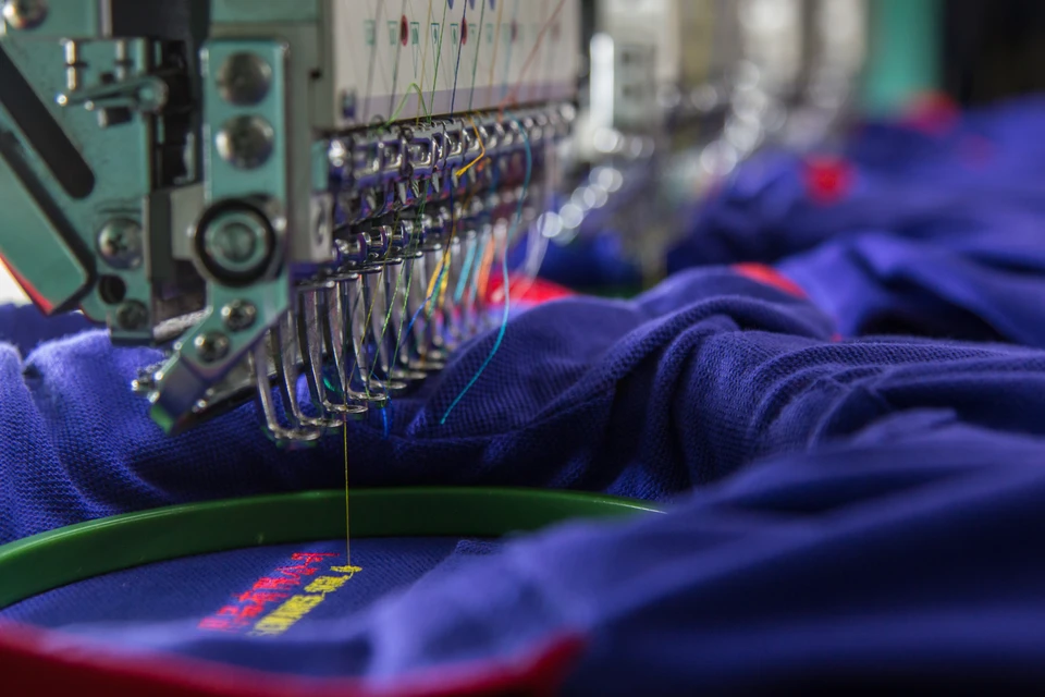 Atelier de broderie industrielle avec machine à broder professionnelle en fonctionnement