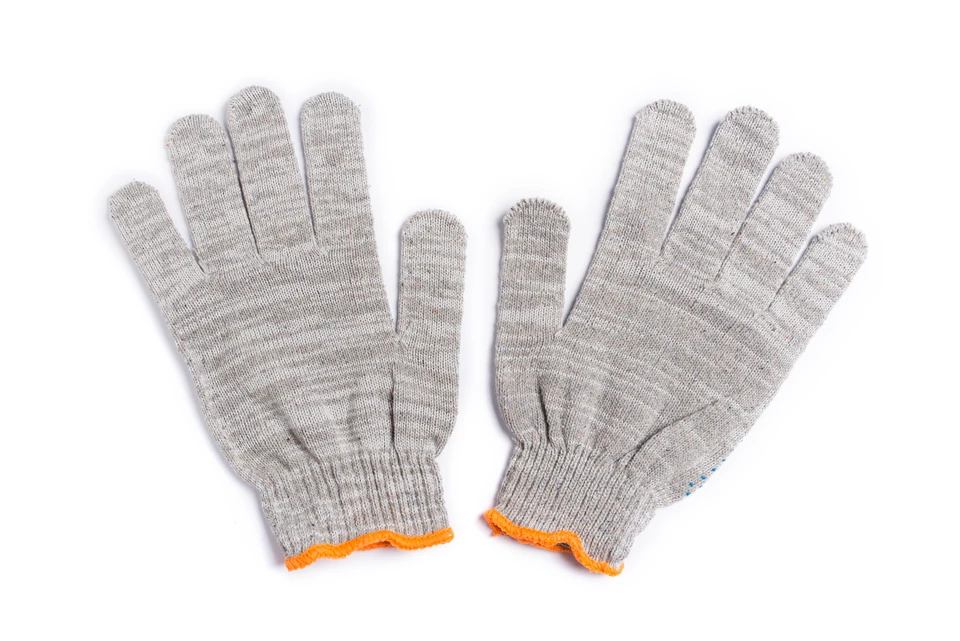 Paire de gants de travail en tricot gris posés sur fond blanc, avec liseré orange au niveau des poignets