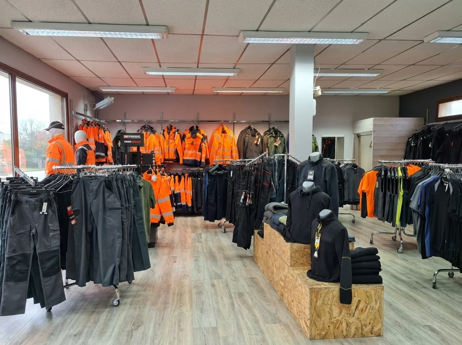 Int&eacute;rieur d'un magasin sp&eacute;cialis&eacute; pr&eacute;sentant des v&ecirc;tements de travail professionnels suspendus sur portants